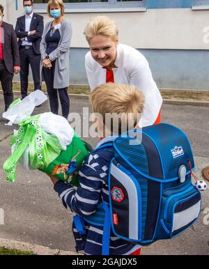 Schwerin, Germania. 31 luglio 2021. Manuela Schwesig (SPD), la Presidente del Ministro del Meclemburgo-Pomerania occidentale, parla con l'antipasto scolastico Aron prima della cerimonia di iscrizione alla scuola elementare di Lankow. Per i circa 14,300 primi classificati nel Meclemburgo-Pomerania occidentale, il tempo scolastico sta per iniziare. Credit: Jens Büttner/dpa-Zentralbild/dpa/Alamy Live News Foto Stock