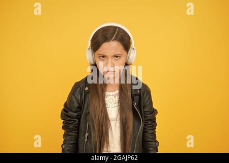 Percezione dei suoni. Testi di apprendimento. Le tendenze della musica plasmano il futuro. Gusto musicale. Accessorio musicale. Negozio di gadget. Piccola ragazza che ascolta la musica senza fili Foto Stock