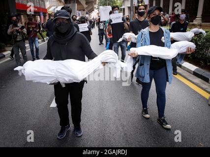 Kuala Lumpur, Malesia. 31 luglio 2021. Durante la manifestazione, i manifestanti detengono corpi falsi.centinaia di malesi con rivestimento nero hanno organizzato una protesta anti-governativa nei pressi di Independence Square a Kuala Lumpur chiedendo le dimissioni del primo ministro per la sua gestione della pandemia del coronavirus, mentre nuovi casi sono saliti in un'impennata che è diventata anche una crisi politica. Credit: SOPA Images Limited/Alamy Live News Foto Stock