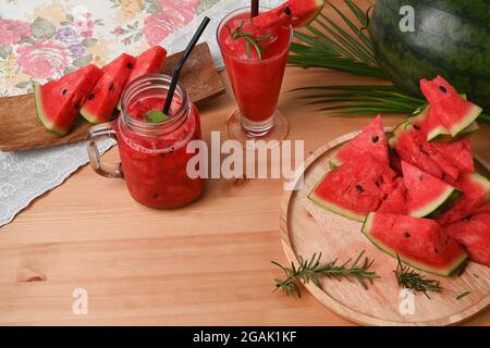 Frullato di anguria in vaso Mason su tavolo di legno. Foto Stock