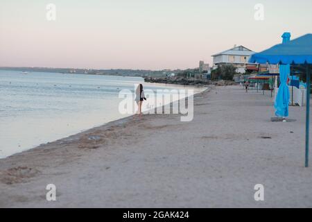Un uomo in piedi sulla cima di una spiaggia di sabbia Foto Stock