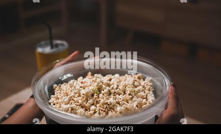 Colpo tagliato di uomo che tiene una ciotola di popcorn. Foto Stock