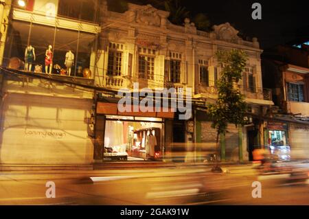 Strada del traffico e la gente vietnamita che cavalcano in bicicletta guidando sulla strada durante la notte alla città vecchia di Ba Dinh o al quartiere francese in piazza di Dong Kinh Nghia Thuc Foto Stock