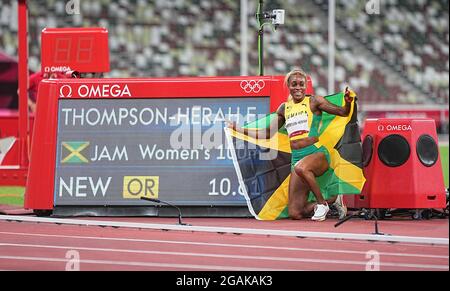 Tokio, Giappone. 31 luglio 2021. Atletica: Olimpiadi, 100 m, donne, finale allo Stadio Olimpico. Elaine Thompson-Herah, il primo classificato della Giamaica, si inginocchia accanto al tabellone segnapunti con il suo record olimpico. Thompson-Herah ha vinto l'oro olimpico nei 100 metri per la seconda volta. Il 34-year-old ha prevalso in 10.61 secondi nella finale ai Giochi estivi a Tokyo il sabato. Credit: Michael Kappeler/dpa/Alamy Live News Foto Stock