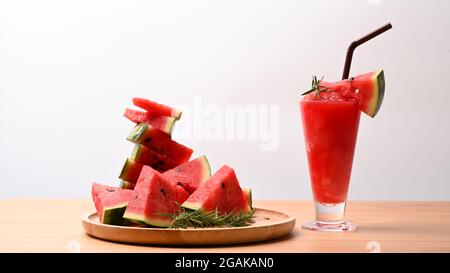 Frullato di cocomero fresco e fette di cocomero su tavola di legno. Foto Stock