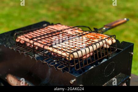 Le salsicce nell'intestino di agnello vengono fritte sulla griglia. Foto Stock