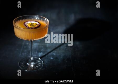 Frutto della passione martini su sfondo scuro Foto Stock