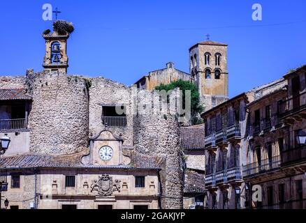 La chiesa romanica e la torre dell'orologio nella piazza principale di Sepulveda . Segovia. Spagna. Foto Stock