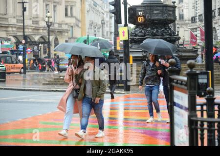 31 luglio 2021, Londra, UK. Persone rifugiate sotto gli ombrelli durante un periodo di pioggia pesante Credit: graham mitchell/Alamy Live News
