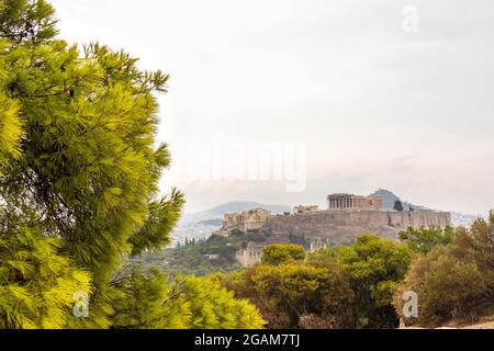 Collina dell'Acropoli (Partenone, Propylaea, Templi, Odeon di Erode Attico) con grande e vivace pineta verde estivo. Antico punto di riferimento storico di Atene Foto Stock