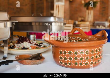 Insalata e pentola di argilla tipica per buffet di piatti messicani tradizionali in Messico Foto Stock