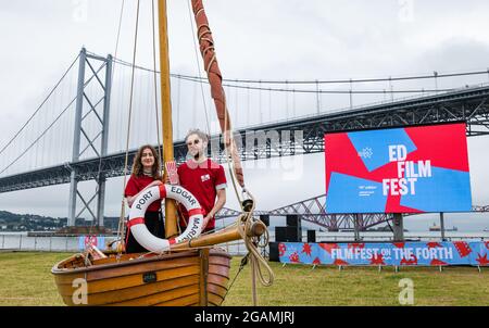 Coppia in piccola barca di legno lancia Edinburgh International Film Festival, Port Edgar, Firth of Forth, Scozia, Regno Unito Foto Stock