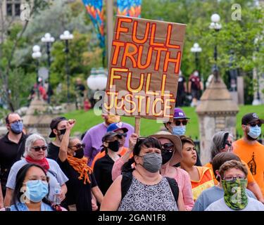 Ottawa, Canada. 31 luglio 2021. Centinaia di persone camminarono dal Parlamento canadese al Ministero della Giustizia chiedendo verità e giustizia per le popolazioni indigene dopo i risultati degli orrori nelle scuole residenziali indiane canadesi. Chiedono un procuratore speciale e un'indagine indipendente sulle azioni del governo e delle Chiese cattoliche in materia. Credit: Meanderingemu/Alamy Live News Foto Stock