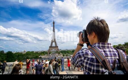 Una persona cattura la Torre Eiffel circondata dai turisti in una giornata di sole a Parigi . Parigi. Francia Foto Stock