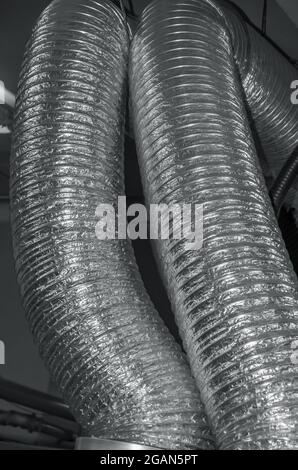 Expandable metallic aluminium corrugated air-conditioning ventilation flexible pipes in closed rooms connecting hood and ventilation air shaft Foto Stock