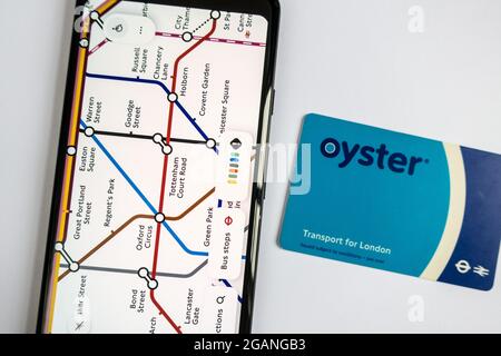 Mappa della metropolitana sullo smartphone e carta Oyster la carta da viaggio Transport for London Foto Stock