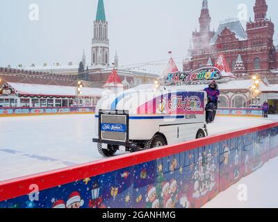 Mosca. Russia. 12 febbraio 2021. La Piazza Rossa. Un'auto pulisce la neve e pulisce il ghiaccio sulla pista di pattinaggio del grande magazzino principale in una giornata invernale durante una nevicata. Foto Stock