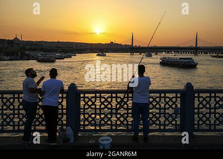 Istanbul, Istanbul, Turchia. 31 luglio 2021. Uomini che pescano al tramonto sul Ponte di Galata. (Immagine di credito: © Serkan Senturk/ZUMA Press Wire) Foto Stock
