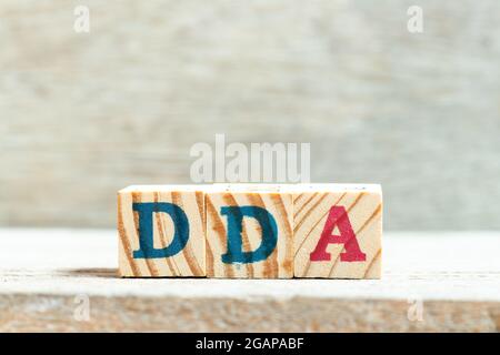 Blocco di lettere alfabetiche in parola DDA (abbreviazione di ammortamento, impoverimento e ammortamento o conto deposito domanda) su sfondo legno Foto Stock