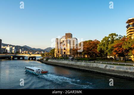 Paesaggio di Hiroshima con vista sul memoriale della Pace di Hiroshima (cupola della Bomba atomica), il fiume Motoyasu e una barca durante il tramonto a Hiroshima, Giappone. Foto Stock