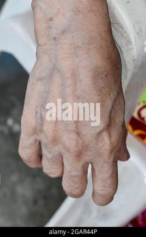 Il Sud-est asiatico, la mano di una vecchia donna del Myanmar. Le pieghe della pelle, la pelle allentata e le vene mostrano invecchiamento. Foto Stock