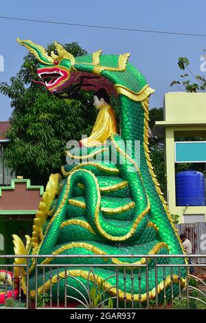 Statua del Buddha di Myanmar sui due draghi verdi birmani. Foto Stock