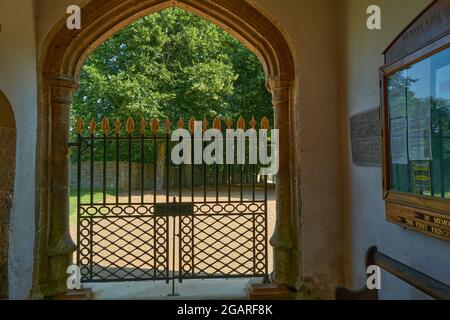 Il portico d'ingresso ad arco e la porta di Santa Maria e di tutti i Santi 15 ° secolo chiesa cristiana nel villaggio inglese di Fotheringhay. Foto Stock