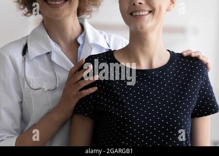 Sorridente gentile medico che sostiene la paziente femminile con cancro. Foto Stock