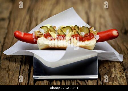 Hot dog in stile danese con tradizionale salsiccia rossa su rustico sfondo di legno Foto Stock