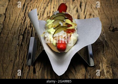 Hot dog in stile danese con tradizionale salsiccia rossa su rustico sfondo di legno Foto Stock