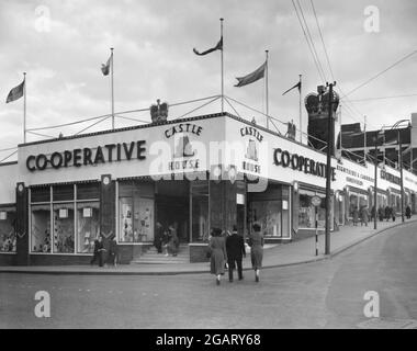 Una panoramica del 1953 del grande magazzino cooperativo di Carbrook, Sheffield, South Yorkshire, Inghilterra, Regno Unito. Notate le decorazioni che erano in atto per l’incoronazione della Regina Elisabetta II di quell’anno La Società cooperativa di Sheffield è stata fondata come Cooperativa Brightside e Carbrook e ha aperto il suo primo negozio nel 1868. Nel 1940 il negozio fu distrutto dai bombardamenti tedeschi durante la seconda guerra mondiale Nel 1950 questo edificio prefabbricato a un piano lo sostituì ed era conosciuto come Casa del Castello (o Casa del Castello No. 1 – il sito faceva parte del castello della città). Nel 1964 fu sostituita dalla Casa del Castello n° 2. Foto Stock