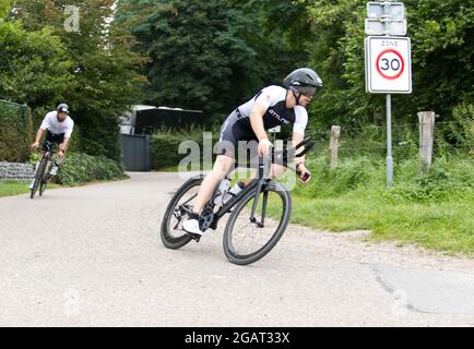 Maastricht, Paesi Bassi. 1 agosto 2021. Marcel Nijsten di Valkenburg (Paesi Bassi) in bici da strada durante il triathlon Ironman 70.3 Maastricht-Limburg, seguito da Maxim Mahoney degli Stati Uniti. A causa dell'acqua che scorre rapidamente nel fiume Mosa a seguito delle recenti inondazioni, la sezione di nuoto del corso è stata sostituita con una sezione di corsa supplementare, trasformando il triathlon in un evento Run-Bike-Run. Anna Carpendale/Alamy Live News Foto Stock