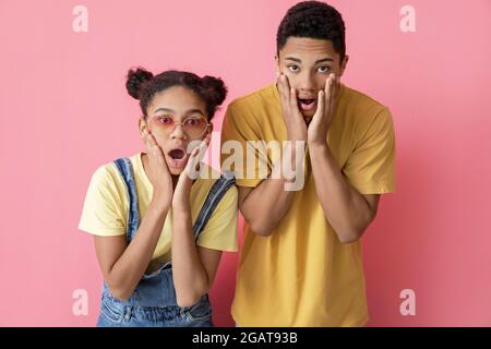 Sorpresi fratello afroamericano e sorella su sfondo a colori Foto Stock