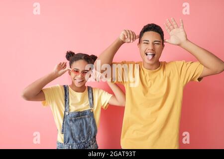 Fratello afroamericano e sorella grimacing su sfondo a colori Foto Stock