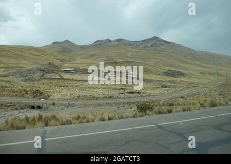 Sulla strada per Puno vicino al Lago Titicaca Perù paesaggio paesaggio paesaggio terreno agricolo strada agricola sentiero cielo nuvole tempo caldo clima tropicale vista pioggia nera Foto Stock