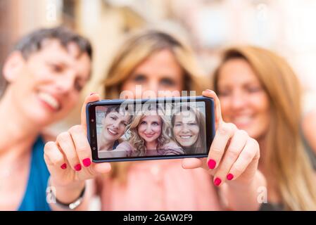 Tre amiche mature che prendono un selfie orizzontalmente Foto Stock
