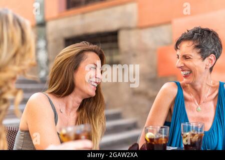 Le donne adulte di mezza età gustano un drink in un bar all'aperto Foto Stock