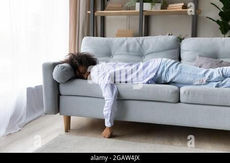 Stanco afroamericano donna dormire su divano a casa Foto Stock