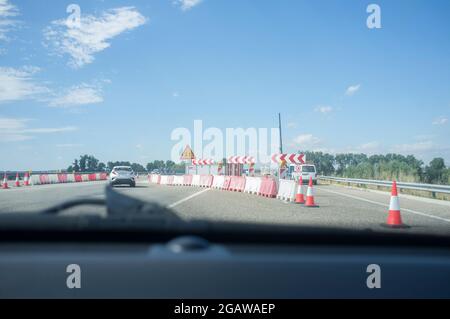 I lavori stradali su un'autostrada deviano il traffico verso una strada temporanea. Vista dall'interno della vettura Foto Stock