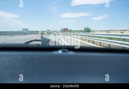 I lavori stradali su un'autostrada deviano il traffico verso una strada temporanea. Vista dall'interno della vettura Foto Stock