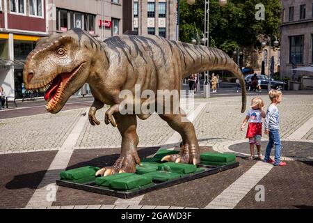 Modelli di dinosauri a grandezza naturale esposti in varie località del centro di Bochum, qui: Tyrannosaurus, Nord Reno-Westfalia, Germania. Lebensg Foto Stock