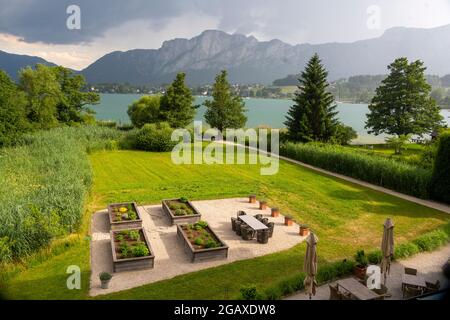 Österreich, Oberösterreich, Mondsee, Blick über den Garten des 'Seehotel Lackner' zur Drachenwand Foto Stock