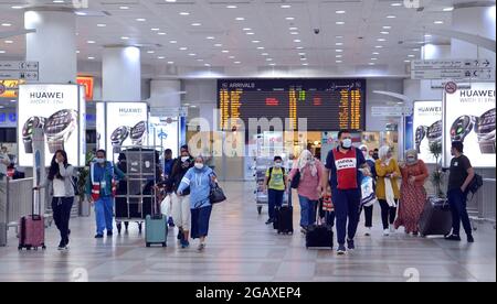 (210801) -- GOVERNATORATO DI FARWANIYA, 1 agosto 2021 (Xinhua) -- i passeggeri camminano nella sala degli arrivi dell'aeroporto internazionale di Kuwait, nel Governatorato di Farwaniya, Kuwait, 1 agosto 2021. L'aeroporto del Kuwait ha iniziato domenica a ricevere gli espatriati vaccinati dopo mesi di divieto di ingresso. (Ningbo) Foto Stock