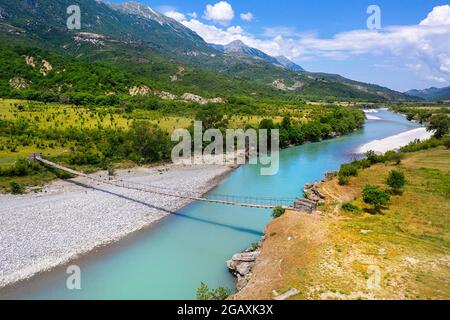 Vecchio ponte sospeso sul bellissimo fiume Vjosa, vicino a Çarçovë, montagne Nemërçka, quartiere Gjirokastra, albania Foto Stock