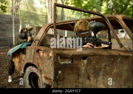 Guerrieri sparare con pistole paintball, gioco di squadra Foto Stock