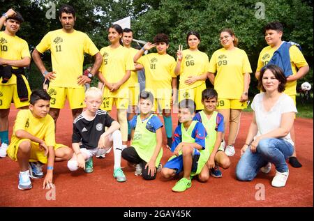 01 agosto 2021, Brandeburgo, Potsdam: Annalena Baerbock (r), candidato alla cancelliera e candidato di Bündnis 90/Die Grünen, squadre per una foto ricordo accanto a bambini e giovani del 'Forster Löwen' (maglia gialla) e due altre squadre durante il torneo calcistico 're:start'. Il torneo 're:start Street Soccer Championship' è organizzato dalla Brandenburg Sports Youth. L'obiettivo è quello di far muovere di nuovo bambini e giovani dopo la pandemia e di ispirare i bambini di una vasta gamma di background familiari a intraprendere lo sport di club. Foto: Soeren Stache/dpa-Zentralbild Foto Stock