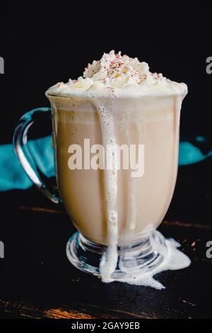 White Chocolate latte con panna montata e cacao in polvere: Una bevanda a base di caffè dolce fatta con cioccolato bianco e panna montata Foto Stock