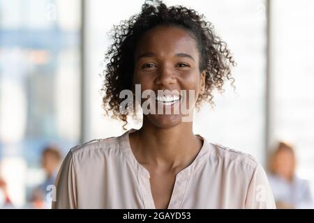 Gioiosa giovane donna d'affari africana che guarda la macchina fotografica. Foto Stock