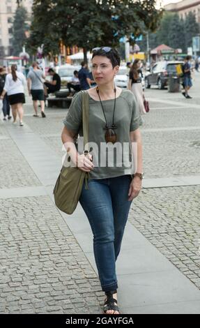 Dnepropetrovsk, Ucraina - 07.28.2021: Una bella donna di mezza età cammina per la città. Alle donne d'affari piace camminare per la città e per te Foto Stock