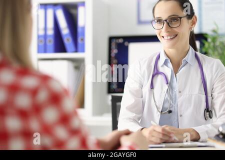 Sorridente medico femminile conduce l'appuntamento medico alla paziente femminile Foto Stock